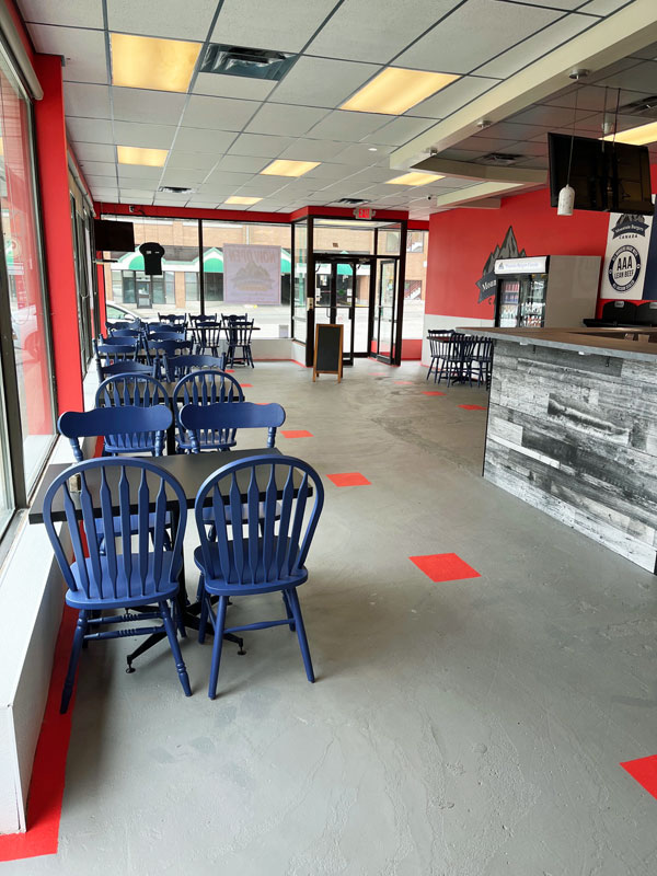 logo on red wall, with table and chairs